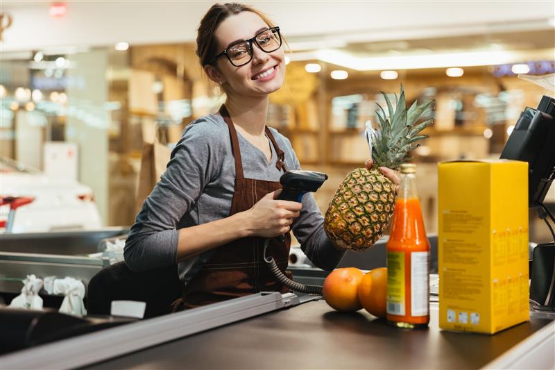 happy-female-cashier-scanning-grocery-items.jpg